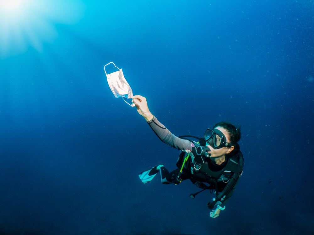 Lady Cleaning the ocean by picking up trash